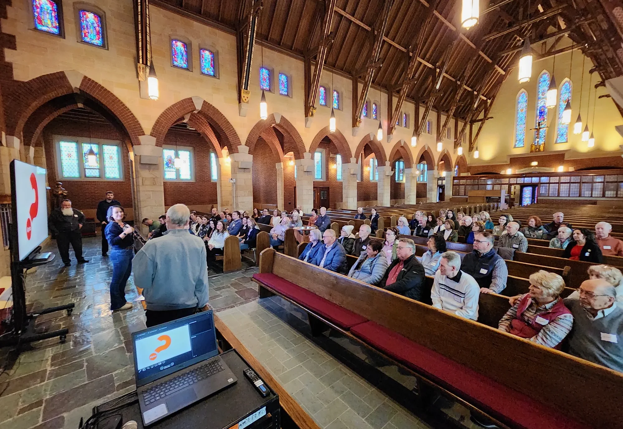 Parishioners in the pews of the church watching an Alpha video