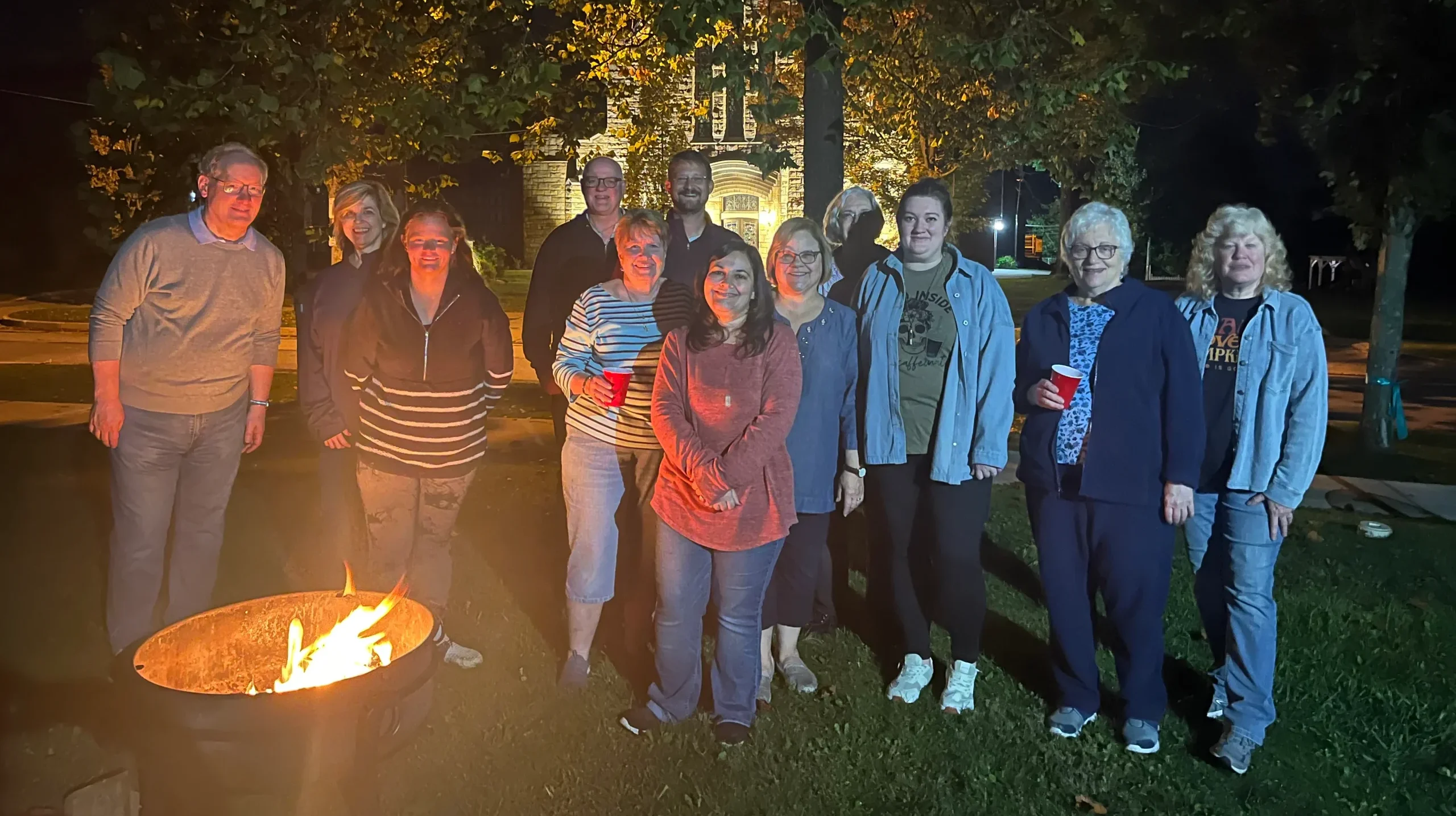A group of parishioners at a campfire