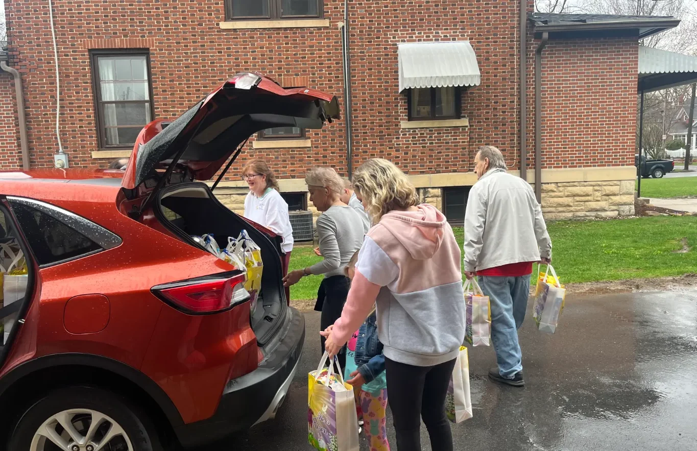 A group of parishioners loading bags into a car